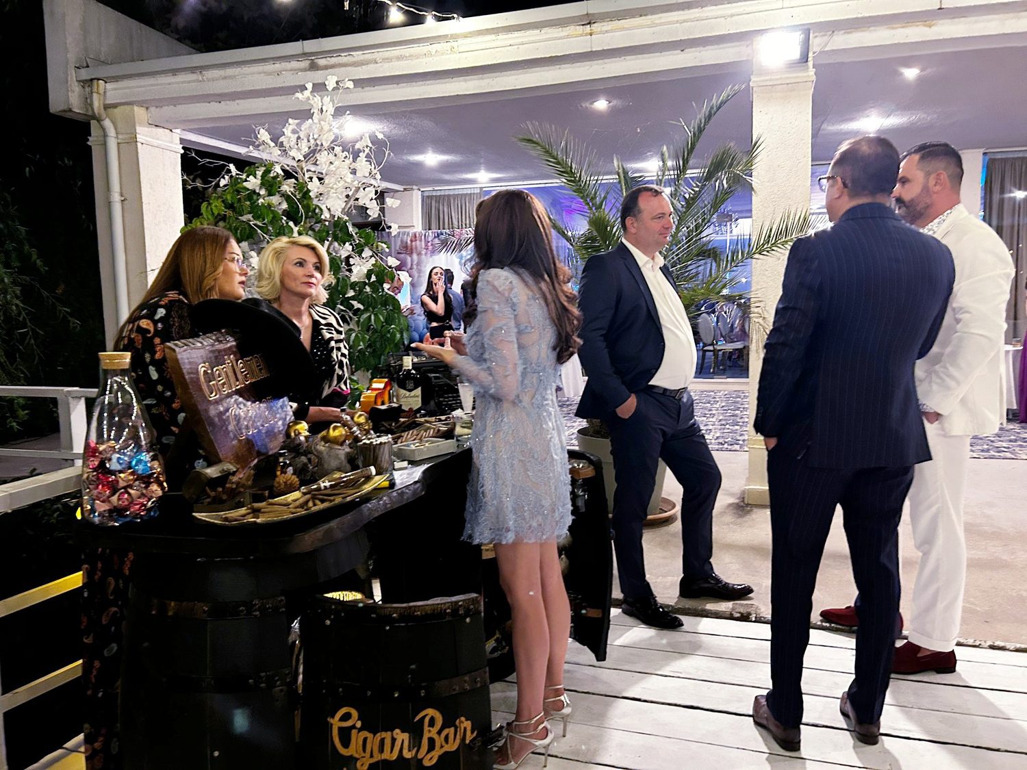 Invitati adunati la cigar bar in timpul unui eveniment de seara